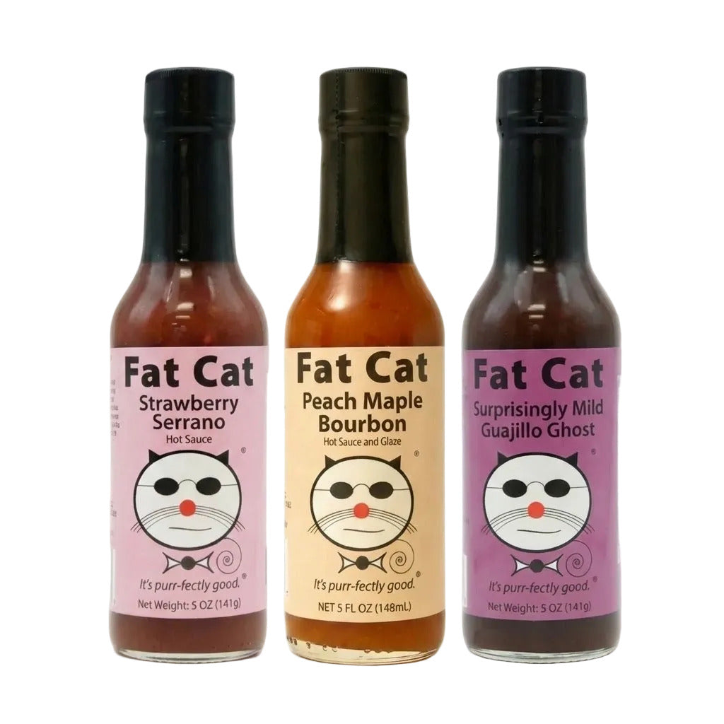 Three bottles of Fat Cat hot sauce with different flavors on a white background