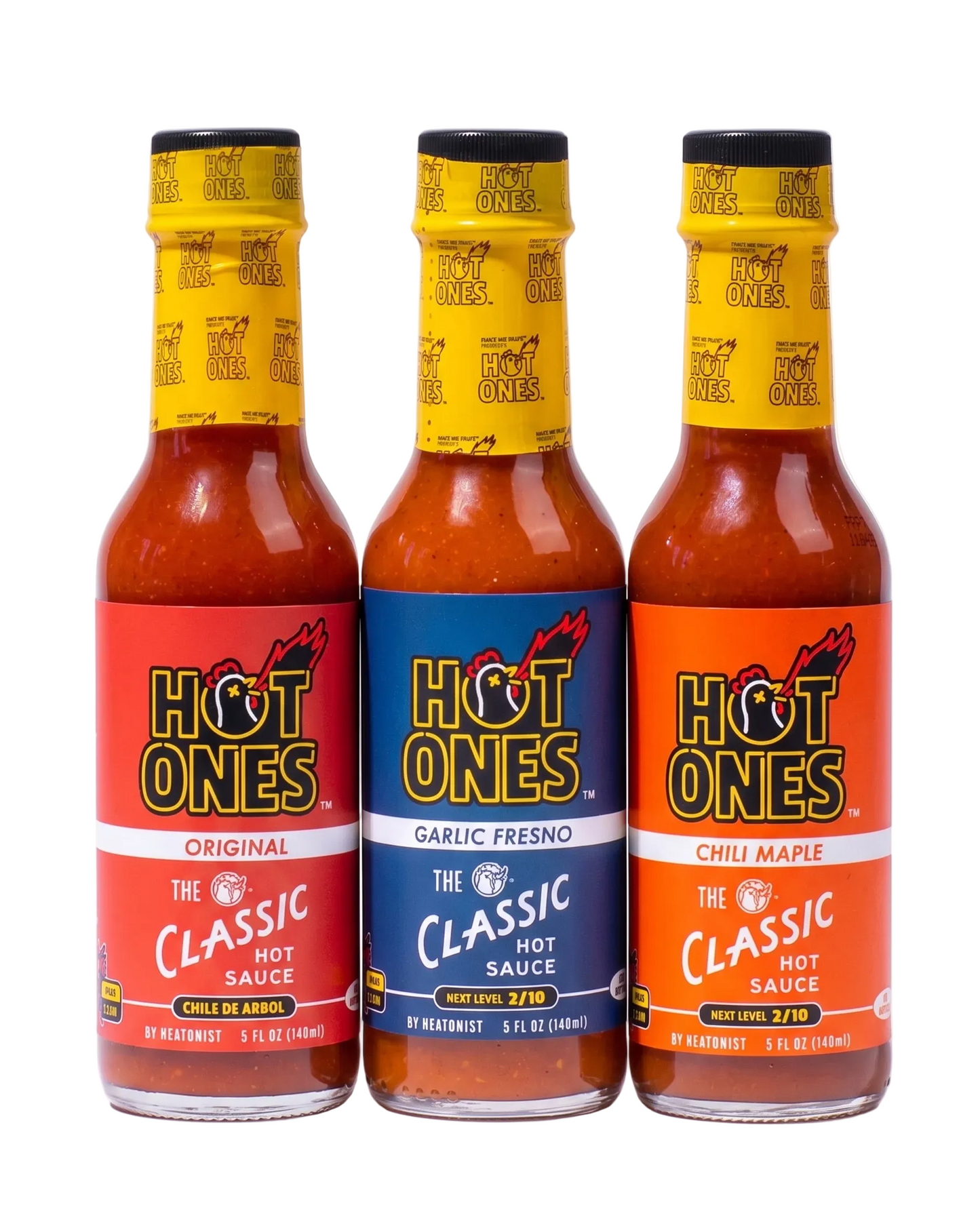 Three bottles of Hot Ones hot sauce with different flavors on a white background