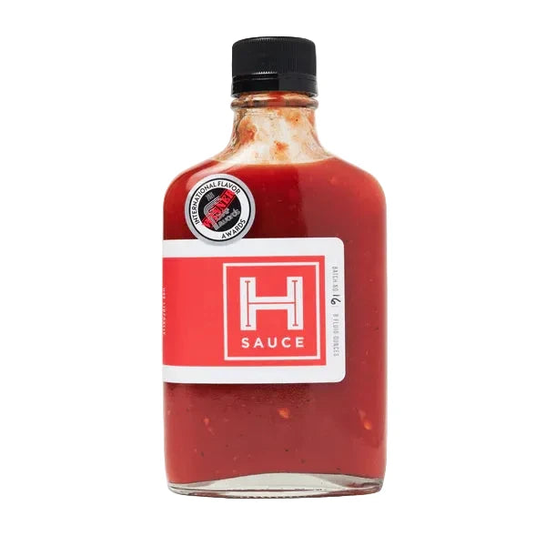 Bottle of H Sauce Original red sauce with a black cap on a white background