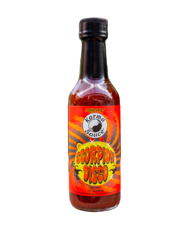 Bottle of Scorpion Disco hot sauce with a colorful label on a surface with plants in the background