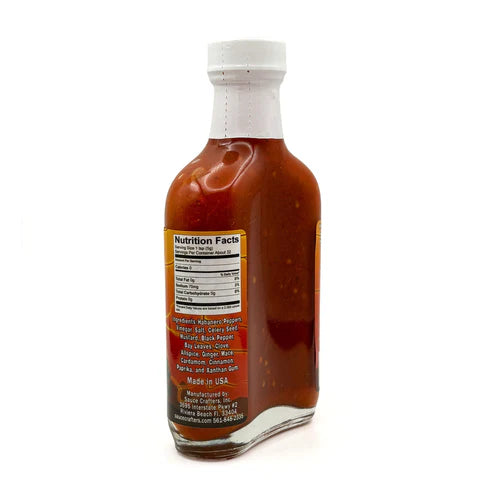 Bottle of hot sauce with a nutrition facts label on a white background