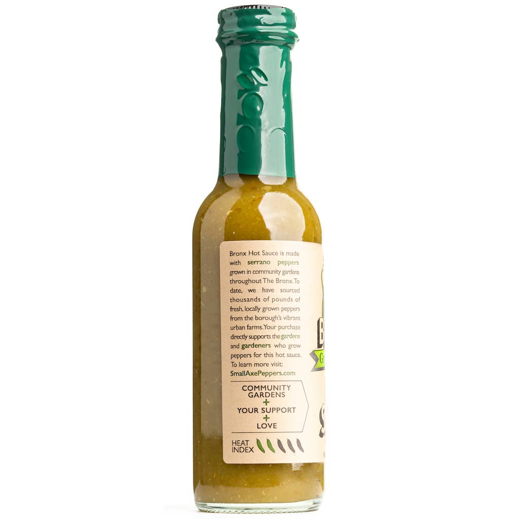 Bottle of Small Axe Peppers The Bronx Green hot sauce with a green cap on a white background