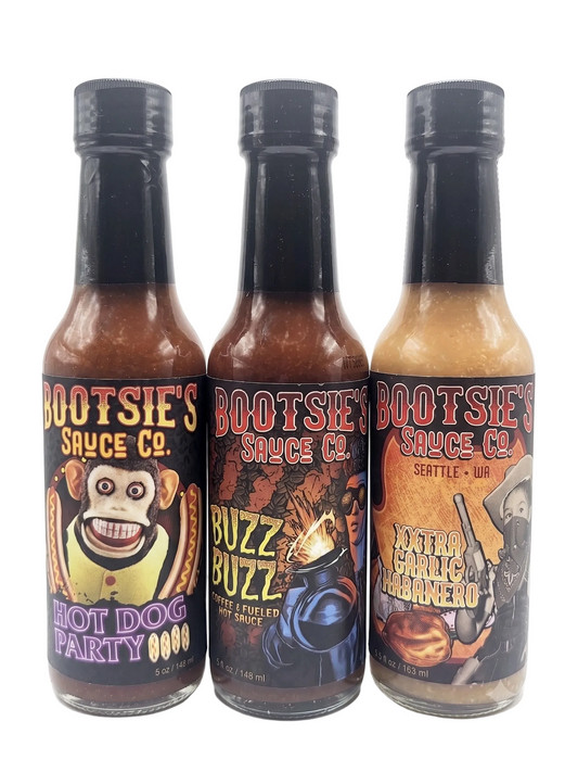 Three bottles of Bootsie's Sauce Co. hot sauce on a white background