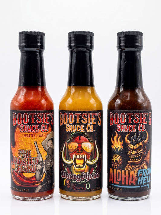 Three bottles of Bootsie's Sauce Co. hot sauce with colorful labels on a white background
