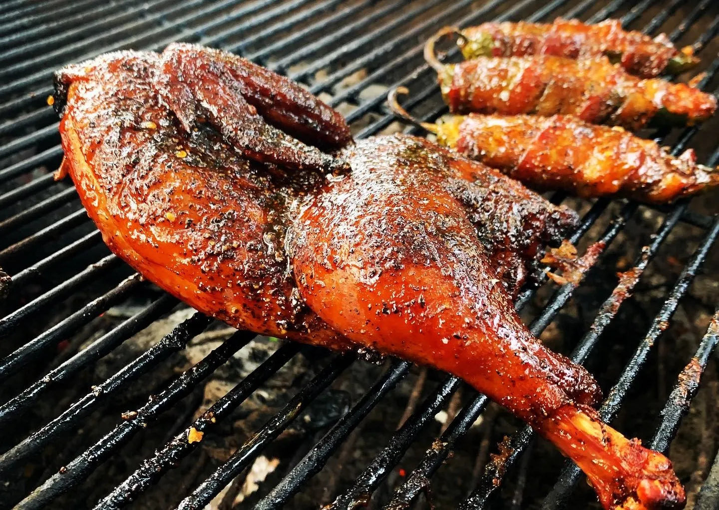 Roasted chicken on a grill with skewered vegetables