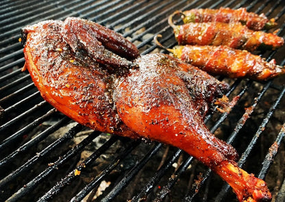 Roasted chicken on a grill with skewered vegetables