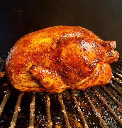 Grilled chicken on a barbecue grill with a dark background