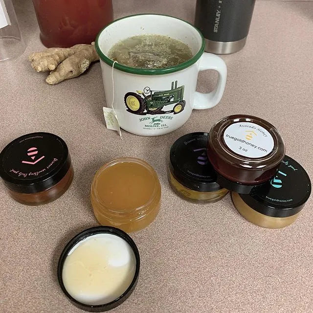 Collection of honey products including jars and a mug on a countertop.