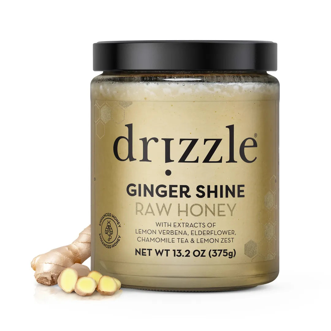 Drizzle Ginger Shine Raw Honey jar with ginger root and honeycomb on a white background