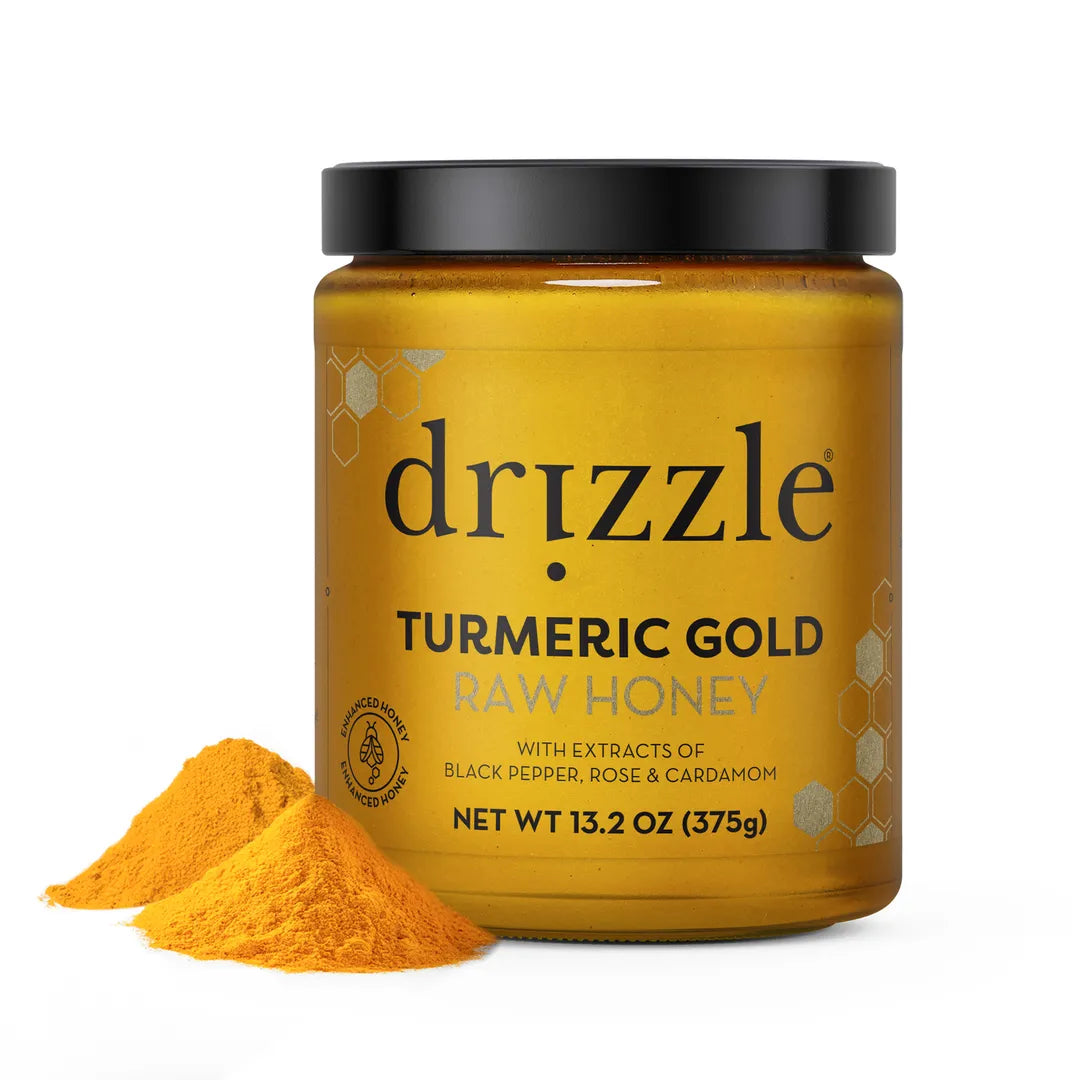Jar of Drizzle Turmeric Gold Raw Honey with turmeric powder on a white background