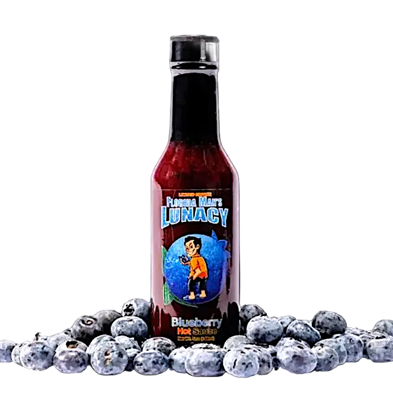 Bottle of 'Flavor Man's Lunacy Blueberry Hot Sauce' surrounded by blueberries on a white background
