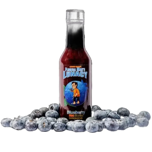 Bottle of 'Flaming Moe's Lunacy Blueberry Hot Sauce' surrounded by blueberries on a white background
