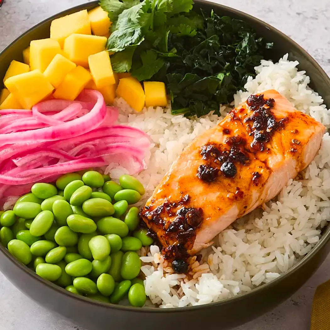 Salmon bowl with rice, salmon with chili crisp, edamame, mango, and pickled radish 