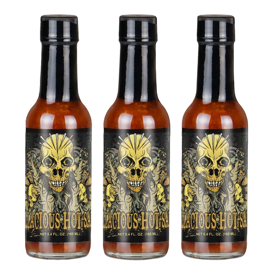 Three identical bottles of Hellacious Hot Sauce arranged side by side on a plain white background. Each bottle contains amber-colored sauce and has a black cap with a black label featuring a large yellow skull illustration and the brand name 'HELLACIOUS HOT SAUCE' in gold lettering.