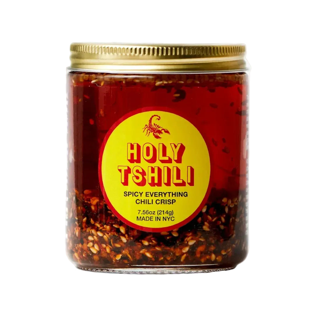 Jar of 'Holy Tshili' spicy everything chili crisp with a gold lid on a white background
