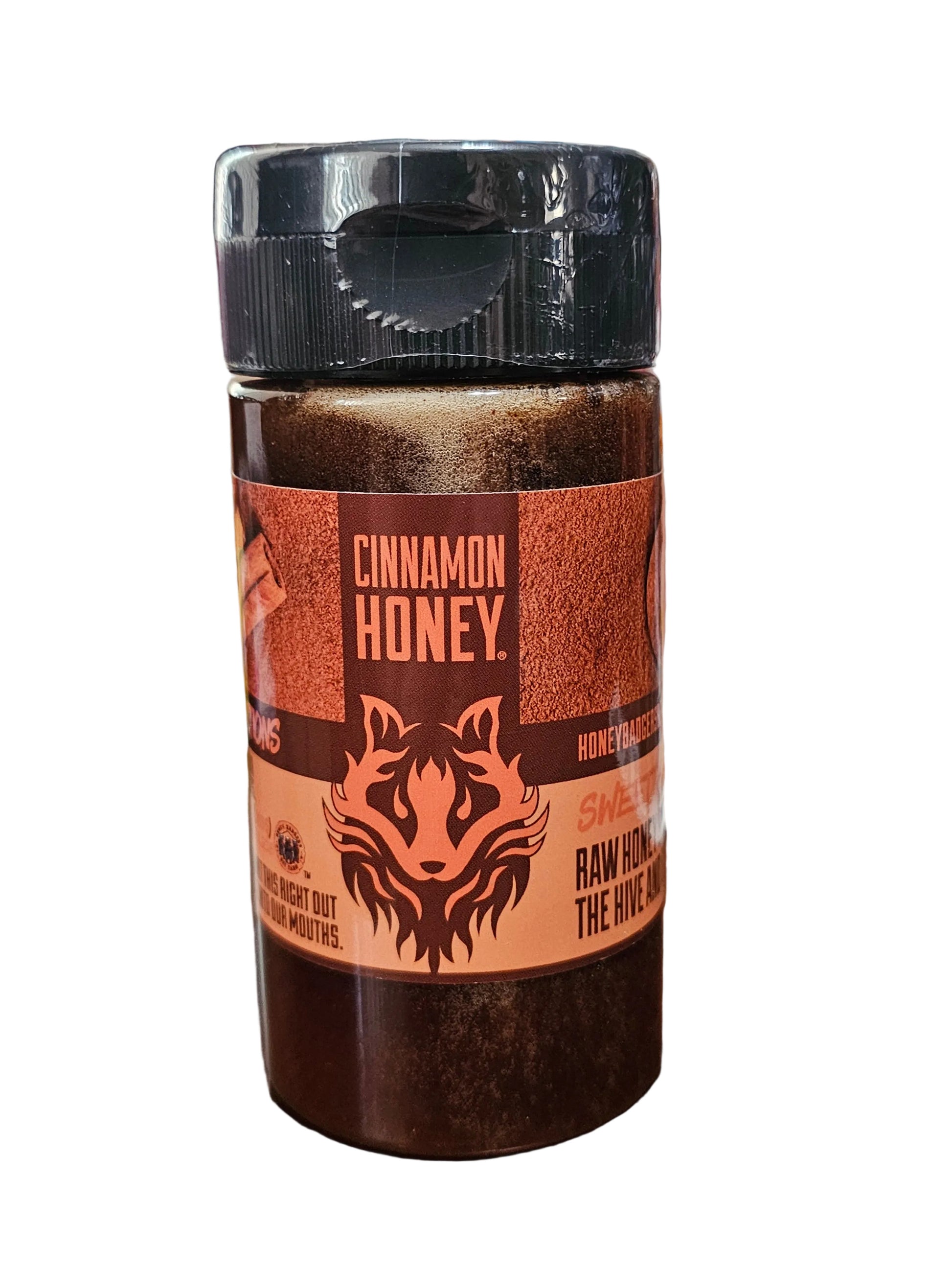 Cinnamon honey container with a label featuring a bear design on a wooden surface.