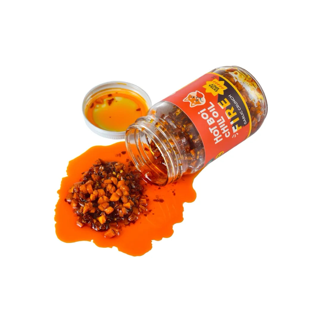 Open bottle of Hot Boi Chile Fire seasoning with chili flakes on an orange background