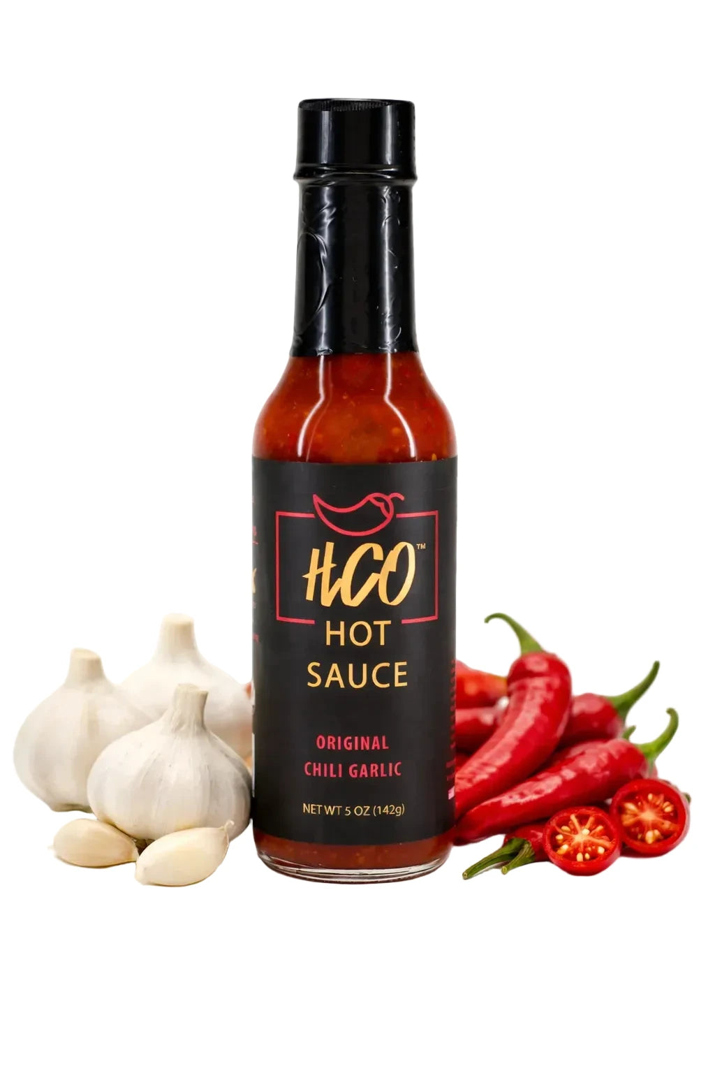 HGO hot sauce bottle with garlic and red peppers on a white background