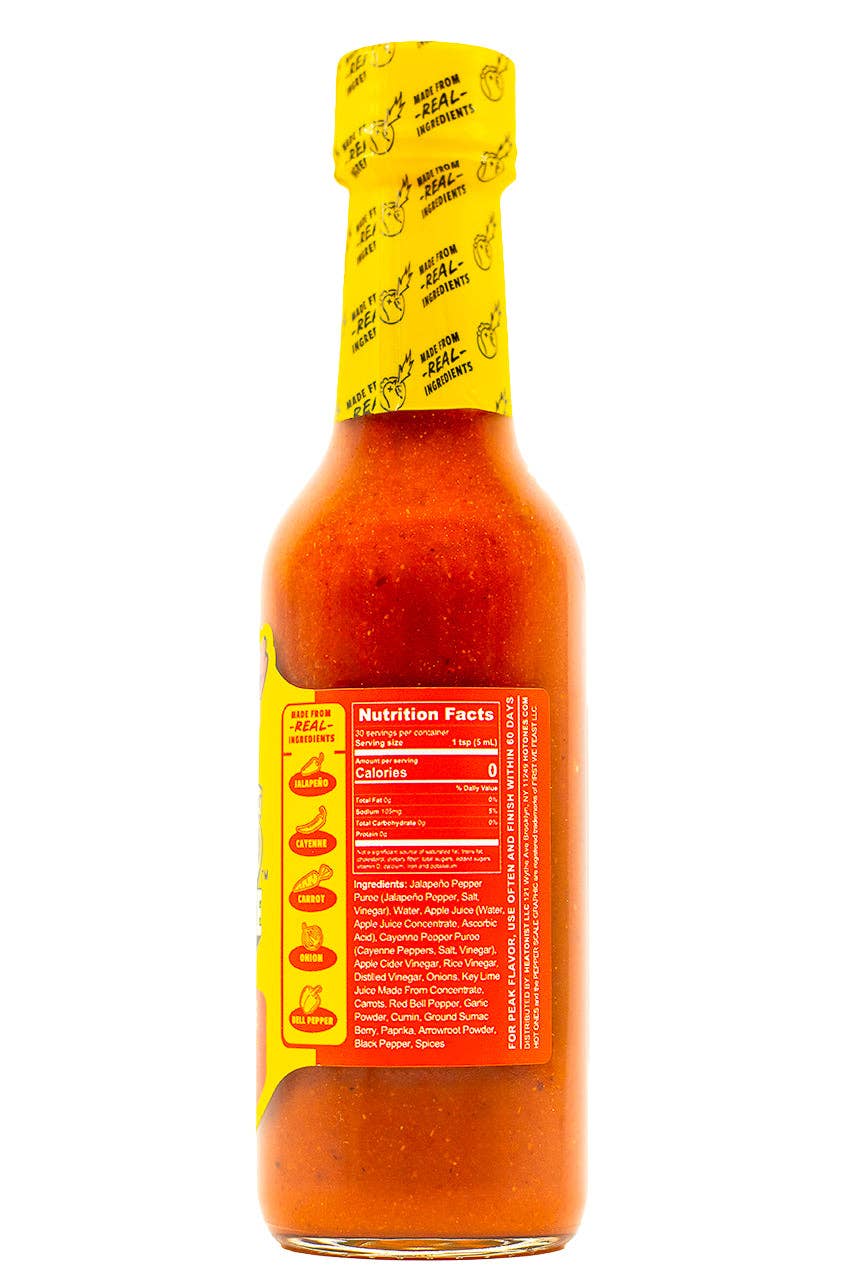A bottle of hot sauce shown from the back, featuring a bright red nutrition facts label and a yellow seal wrapper around the neck, isolated on a white background.