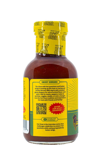 Bottle of Hot Ones Smoky Serrano hot sauce with yellow label on a white background