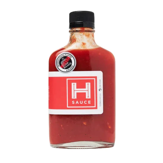 Bottle of H Sauce Original red sauce with a black cap on a white background