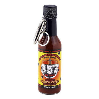 A bottle of 357 Hot Sauce by Mad Dog Schoville with a black cap and a silver metal keychain attached, shown on a plain white background.
