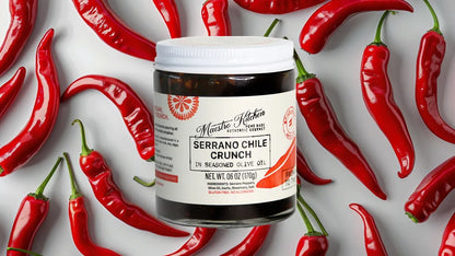 Maestro Kitchen Serrano Chile Crunch with peppers surrounding the jar