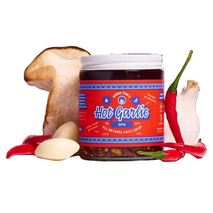 Jar of 'Hot Garlic' with garlic, chili peppers, and a mushroom on a white background