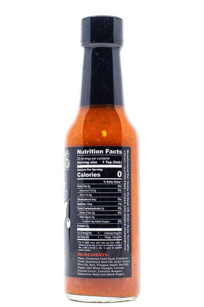 A bottle of hot sauce with an orange-red sauce visible through the glass, featuring a black cap and a black label displaying nutrition facts.