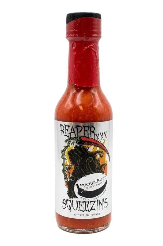 A bottle of Squeezin's 'Raptor' hot sauce with a red cap and a white label featuring a black raptor illustration, set against a plain white background.