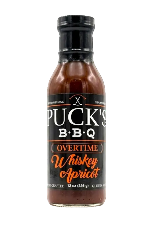 Bottle of Puck's BBQ Overtime Whiskey Apricot sauce on a white background