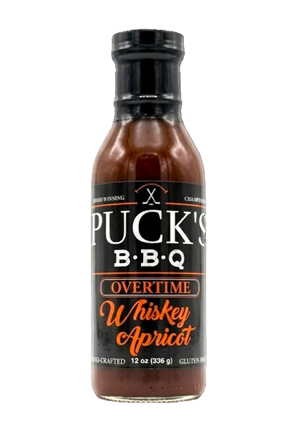 Bottle of Puck's BBQ Overtime Whiskey Apricot sauce on a white background
