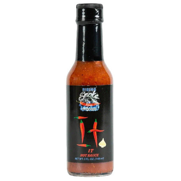 Bottle of Rising Smoke hot sauce with a black label