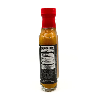 Bottle of hot sauce with a red cap on a white background