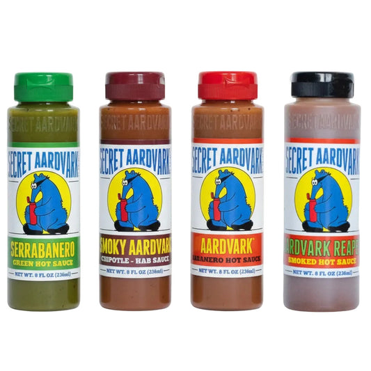 Four bottles of Secret Aardvark hot sauce with colorful labels on a white background