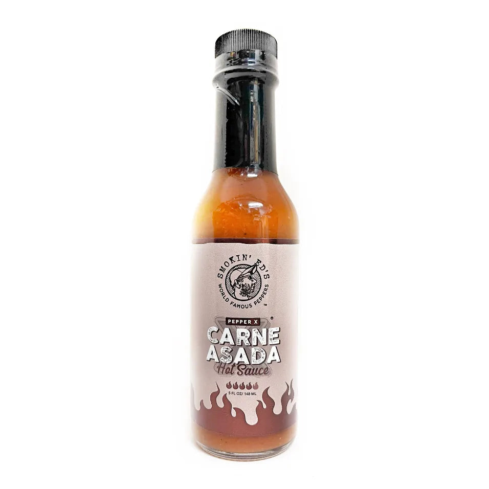 A bottle of Smokin Ed's Carne Asada Hot Sauce on a solid white background. The bottle contains a reddish-brown sauce and features a black cap and a beige label with the product name in bold white and black text.