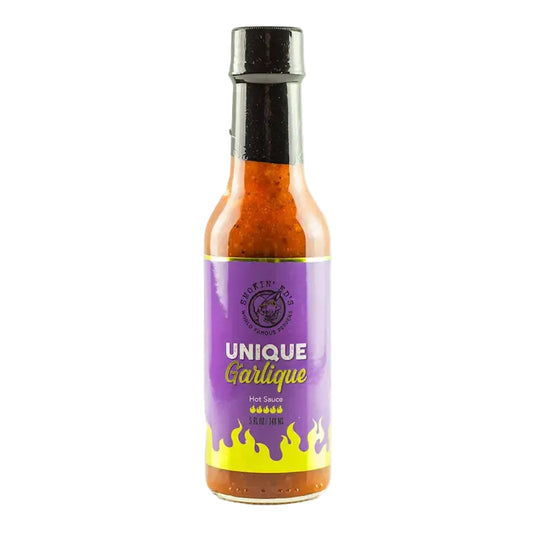 A bottle of Unique Garlic Hot Sauce with a purple label and yellow flame design, set against a light gray background.