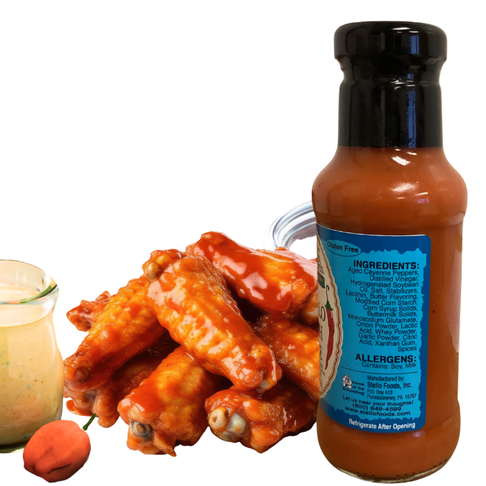 Bottle of Stello Foods hot sauce with wings and buttermilk on a yellow background