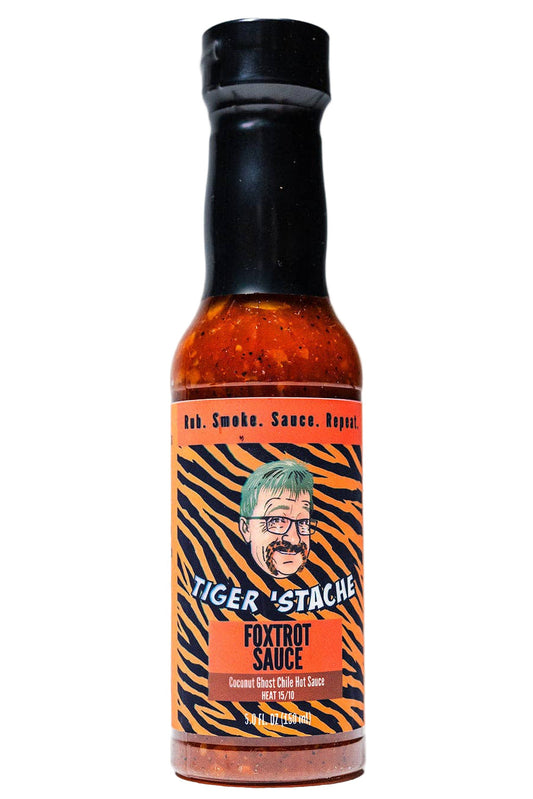 Bottle of Tiger 'Stache Foxtrot Sauce with a black cap on a white background
