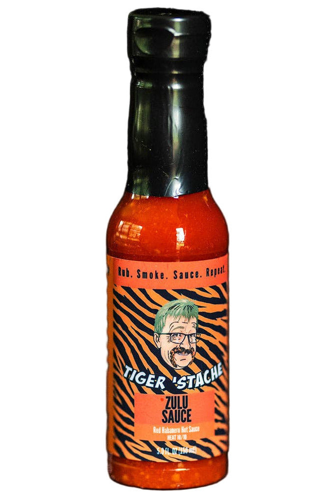 Bottle of Tiger Stache Zulu hot sauce on a dark background