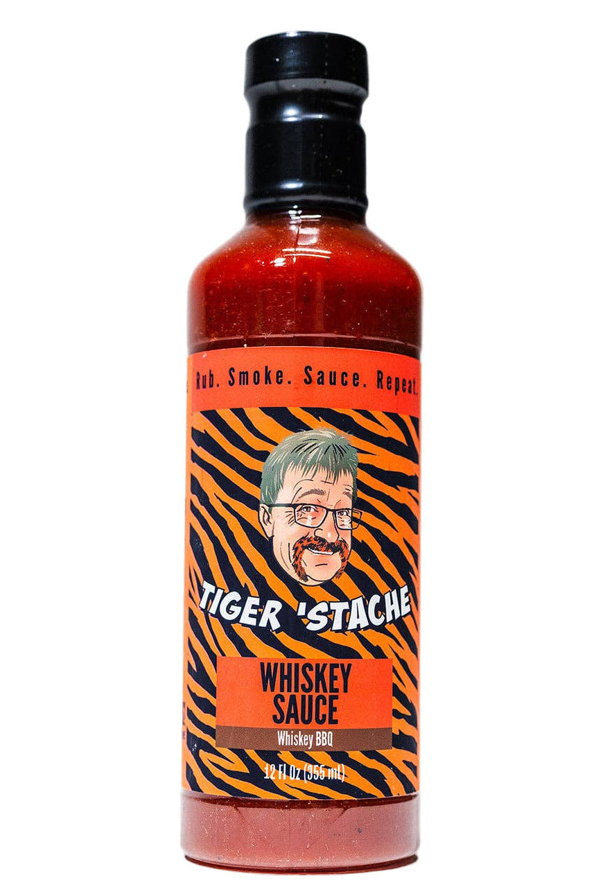 Bottle of Tiger Stache Whiskey Sauce with a tiger stripe label on a white background