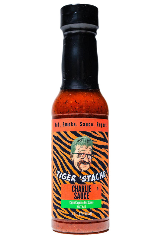 Bottle of Tiger Stache Charlie Sauce with a black cap on a white background