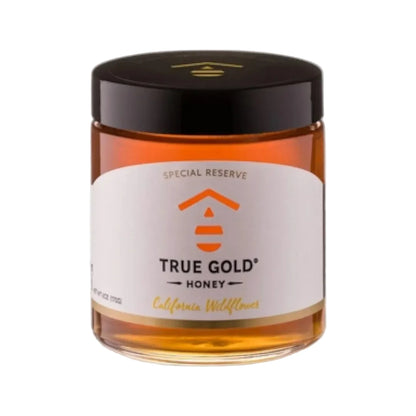 Jar of True Gold Honey with a black lid on a white background