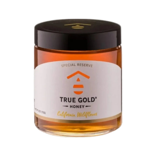 Jar of True Gold Honey with a black lid on a white background