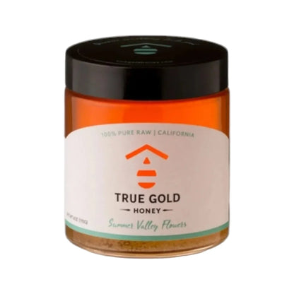 Jar of True Gold Honey with a black lid on a white background