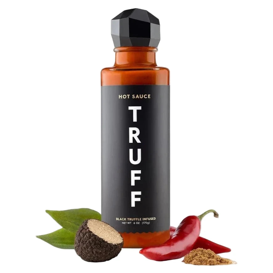 Hot sauce bottle labeled 'TRUFF' with black truffle, red pepper, and green leaf on a white background