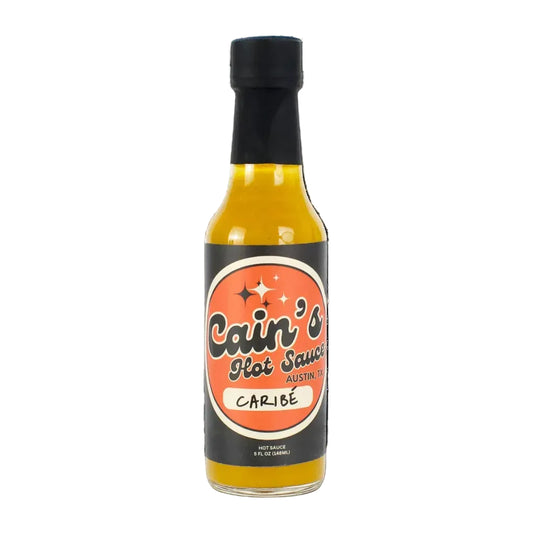 Bottle of Cain's Hot Sauce Caribe on a white background