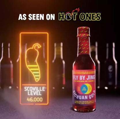 Bottle of Fly by Jing Sichuan Gold hot sauce with a Scoville level display, set against a dark background with 'Hot Ones' branding.