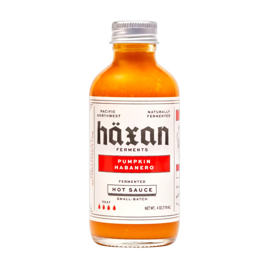 Bottle of Häxan Pumpkin Habanero hot sauce on a white background