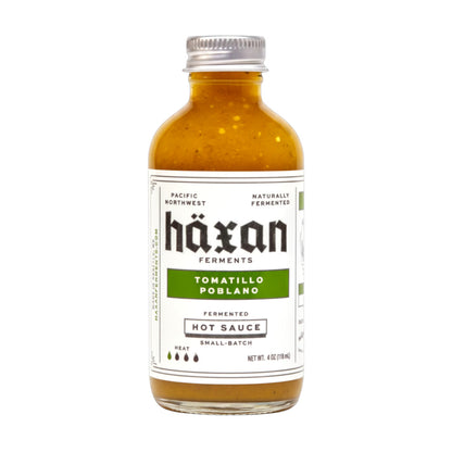 Bottle of Häxan Tomatillo Poblano hot sauce on a white background